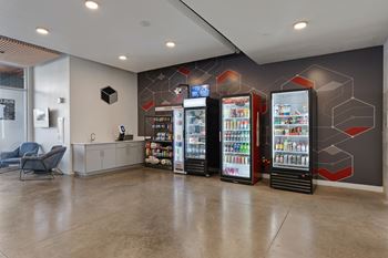 A room with a vending machine and a chair.